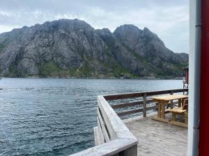 a dock with a table and a view of a mountain at Rorbu in Nusfjord, Lofoten in Nussfjord