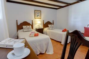 a room with two beds and a table with a cup on it at Clara Suite 2 - Macaronesiahomes in Masdache +17 photos