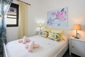 a bedroom with a white bed with pink towels on it at Caleta Blue House - Macaronesiahome in Caleta de Caballo