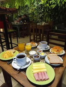 a wooden table with plates of food and cups of coffee at Huella Andina in San Carlos de Bariloche