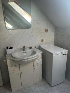 a bathroom with a sink and a washer and dryer at Willa Aqua -parking included in the price in Świnoujście +28 photos