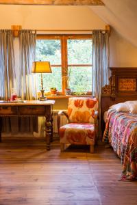 a bedroom with a bed and a desk and a window at Siódmy Las in Zawada