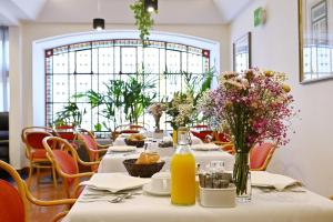 a long table with flowers and bottles of orange juice at Hotel Principe Real in Lisbon