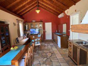 a kitchen with red walls and a table and chairs at AMYGDALIA in Vlachopoulátika