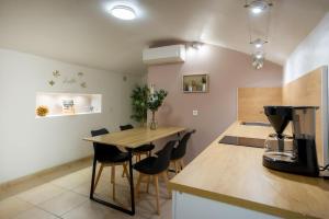 a kitchen with a counter and a table with chairs at Le Cocon Vouté, air-conditioned in Saint-Laurent-des-Arbres
