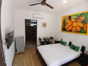 a bedroom with a bed and a painting of oranges at Hotel Jaco Lodge in Jacó