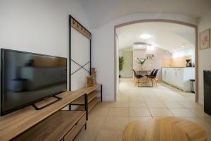 a living room with a large flat screen tv at Le Cocon Vouté, air-conditioned in Saint-Laurent-des-Arbres