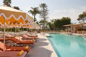 a pool at a resort with chairs and umbrellas at Kimpton Los Monteros Marbella by IHG in Marbella