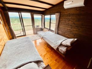 a room with two beds in a room with windows at DeepSpot - Vacation STAY 19274v in Minamioguni