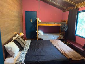 a bedroom with two bunk beds and a window at Pousada Tiê-Sangue in Iporanga