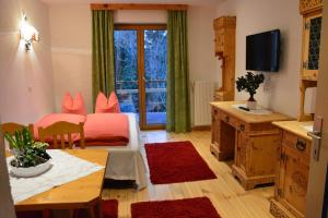 a room with two beds and a table and a television at Nattererboden in Innsbruck