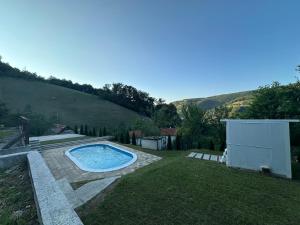 a backyard with a swimming pool in the grass at Happy House in Sarajevo