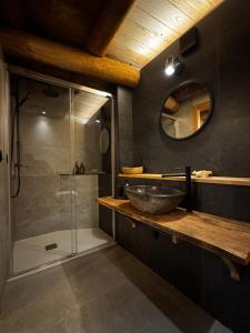 a bathroom with a sink and a glass shower at A Barreira -Lar da cima- in Folgoso