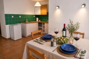 a kitchen with a table with blue plates and wine glasses at Natasa private garden apartment in Polychrono
