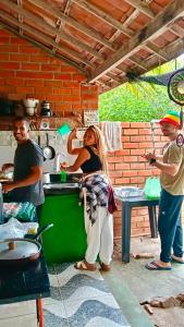 a group of people standing in a kitchen at Canoa Roots Hostel & Camping in Canoa Quebrada