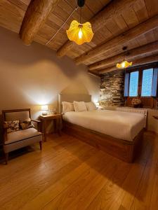 a bedroom with a large bed and a stone wall at A Barreira -Lar da cima- in Folgoso +52 photos