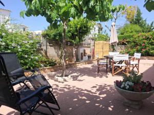 a patio with a table and chairs and a tree at Llar Montagut in Torredembarra