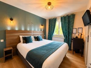 a bedroom with a large bed and a television at Logis Hôtel Centrotel et Spa Bulles d'Allier in Montmarault