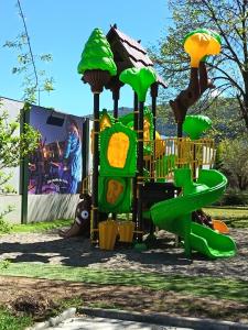 a playground with a green slide in a park at Camping du lac chalet P62 in Foix
