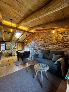 a living room with a blue couch and a table at A Barreira -Lar da cima- in Folgoso