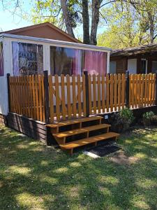 a wooden bench in front of a house at Camping du lac chalet P62 in Foix