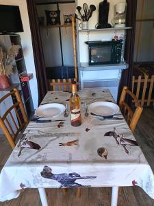a table with a bottle of wine on top of it at Camping du lac chalet P62 in Foix +2 photos