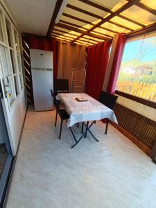 a kitchen with a table and chairs and a refrigerator at Camping du lac chalet P62 in Foix
