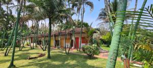 a house with palm trees in front of it at Arco Iris Chales II in Maresias
