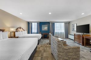 a hotel room with two beds and a flat screen tv at Best Western Plus Dubuque Hotel and Conference Center in Dubuque