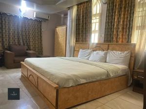a bedroom with a large bed in a room at Luxritel Hotel Abuja in Kajewole