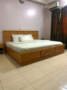 a bed in a bedroom with a wooden bed frame at Luxritel Hotel Abuja in Kajewole +7 photos
