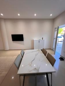 a dining room with a white table and chairs at Aron apartments in Tirana