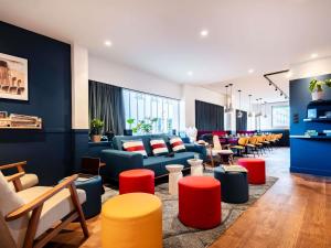 a living room with couches and tables and chairs at Ibis Styles Rouen Centre Cathédrale in Rouen