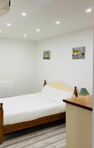 a bedroom with a large bed with white sheets at Ideal Guest House in Carrick-on-Suir