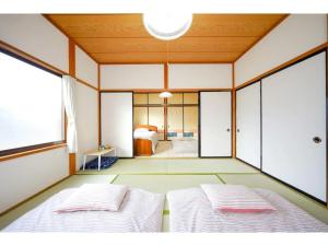 two beds in a room with a bedroom at Second House Nikko - Vacation STAY 13408 in Nikko
