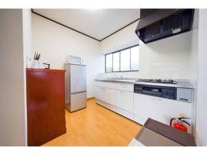 a kitchen with white cabinets and a stainless steel refrigerator at Second House Nikko - Vacation STAY 13408 in Nikko