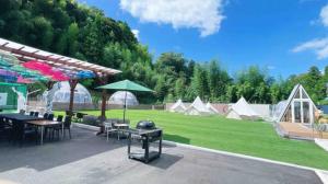 a patio with a grill and tables and chairs and tents at Camp studio - Vacation STAY 89015v in Ichihara