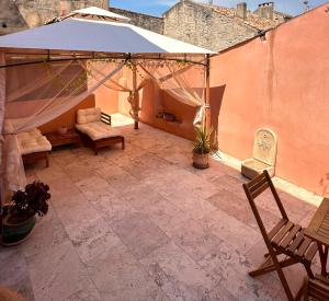 a patio with a tent and a couch and a chair at L'Escale Romaine - Expérience Antique Unique - Centre Historique Orange in Orange