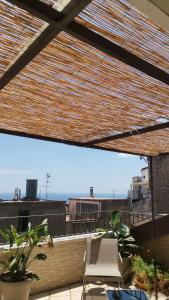 a patio with a chair and plants on a roof at Donna Rosa - Main Avenue in Taormina