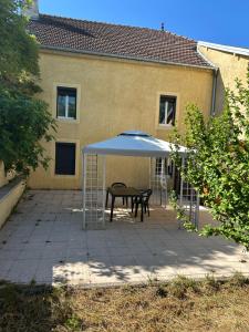 a patio with a table and a blue umbrella at LEMAFIOlY in Cemboing +4 photos