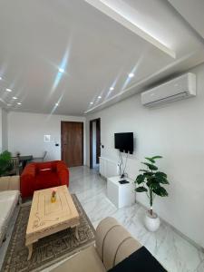 a living room with a red couch and a table at Appartement de luxe in Tunis