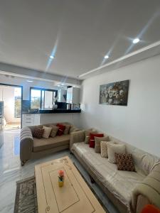 a living room with two couches and a table at Appartement de luxe in Tunis