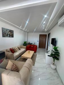a living room with couches and a table and a tv at Appartement de luxe in Tunis