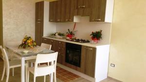a kitchen with a table and a stove top oven at La Playa Del Sol Tropea in Santa Domenica