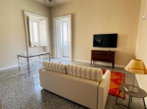 a living room with a couch and a table at Residenze Candida - Casa Bianca in Locri +4 photos