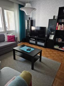 a living room with a coffee table and a tv at Apartment with private sauna in Loimaa