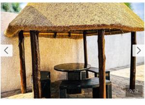 a small hut with a table and a stool at Queen Room self contained in Lusaka