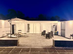 a patio with chairs and an umbrella at night at Villa le dalie in Mascalucia