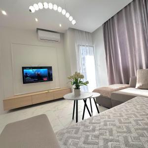 a living room with a couch and a tv on a wall at Joel Family Apartment's Golem Center in Golem
