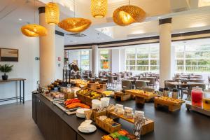 a restaurant with a buffet line with tables and chairs at Intercity Itupeva in Itupeva